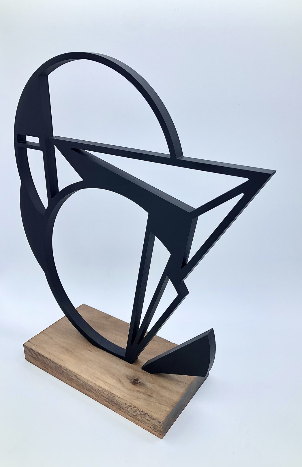 A black and white sculpture on a wooden base.