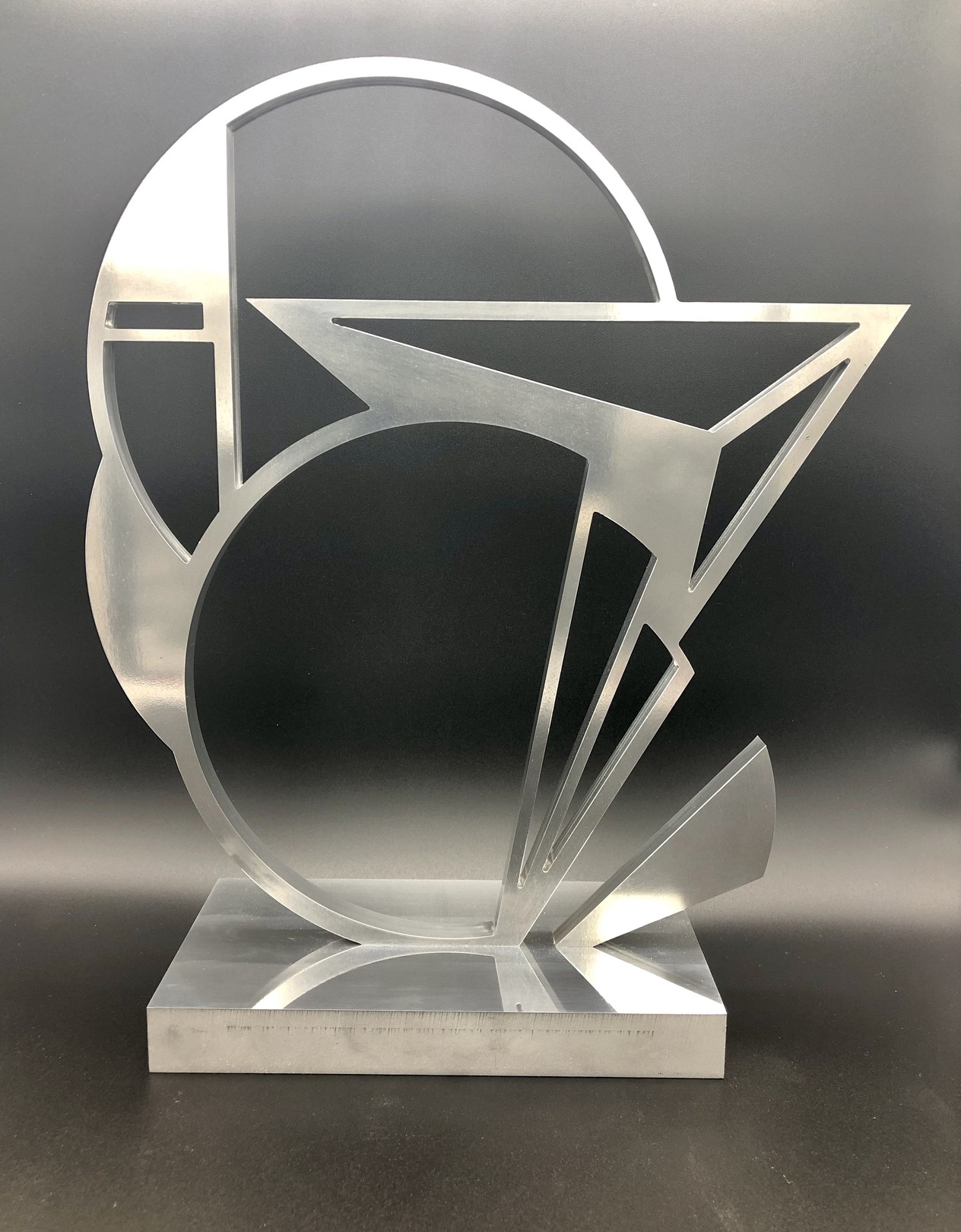 A metal sculpture on a metal base on a table.