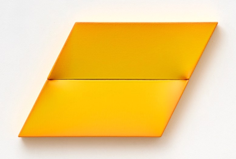 An orange folded piece of paper on a white surface.