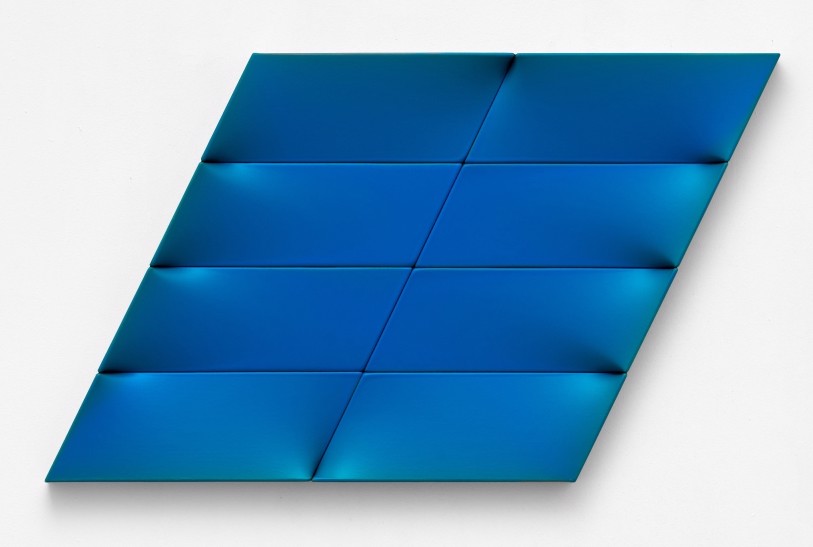 A blue piece of art that is on a white surface.