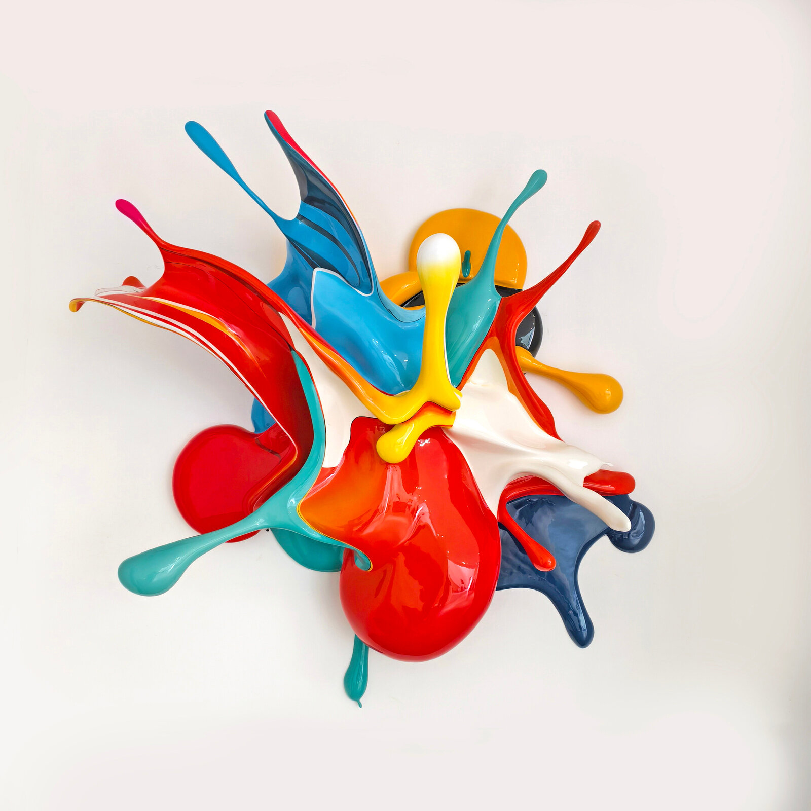 A dynamic, glossy sculpture of colorful paint splashes frozen in mid-air against a plain background.