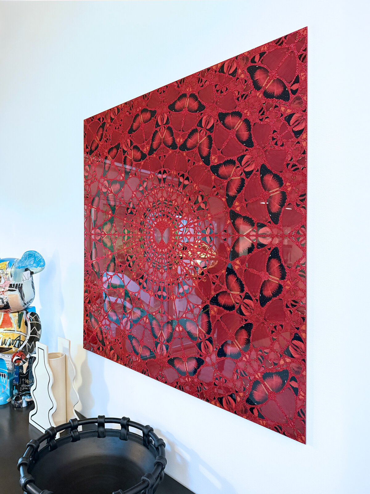 A kaleidoscopic mandala of red and black butterflies spiraling inward.