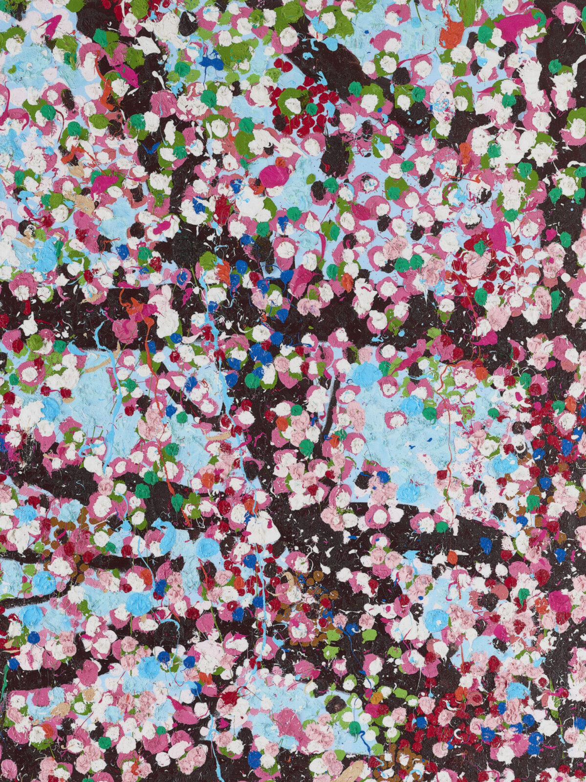 A dense, colorful tree in full bloom against a light blue sky.