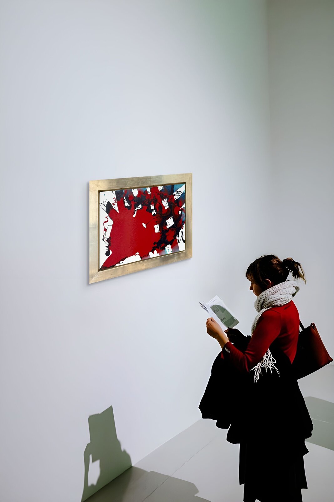 A dynamic abstract painting featuring a bold red shape against a white background with black and blue accents.