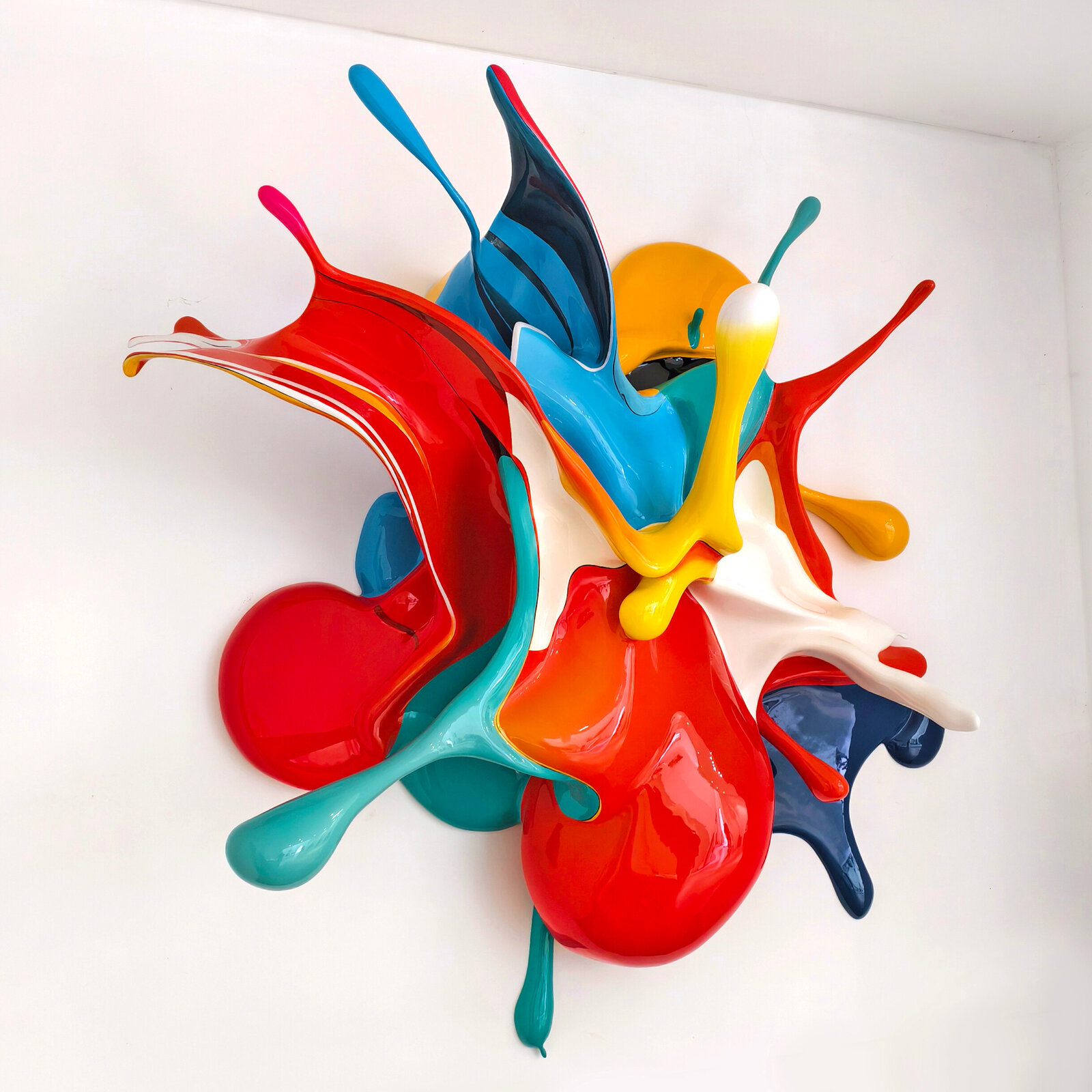 A dynamic, glossy sculpture of colorful paint splashes frozen in mid-air against a plain background.