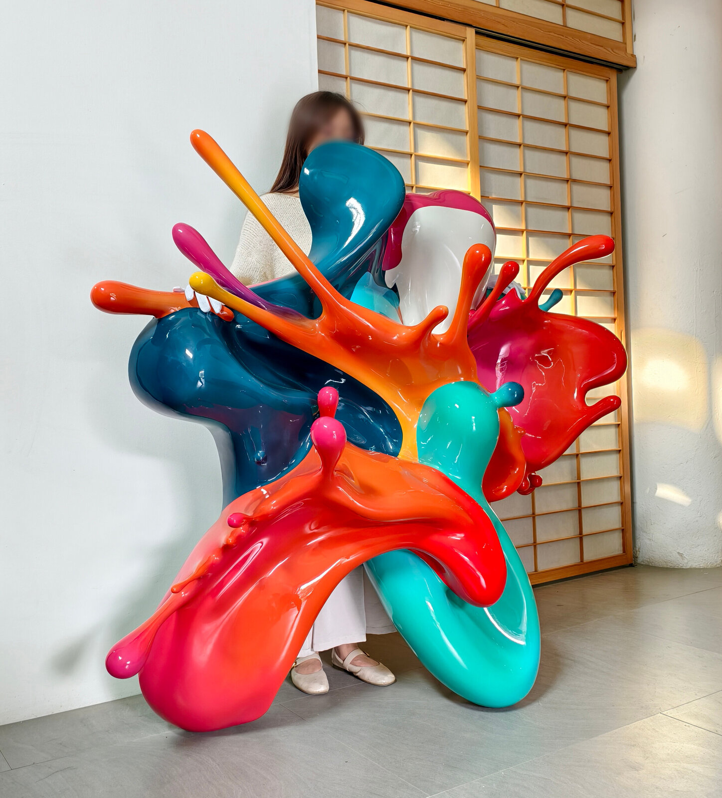 A dynamic sculpture of glossy, multi-colored paint splashes frozen in motion against a plain white background.