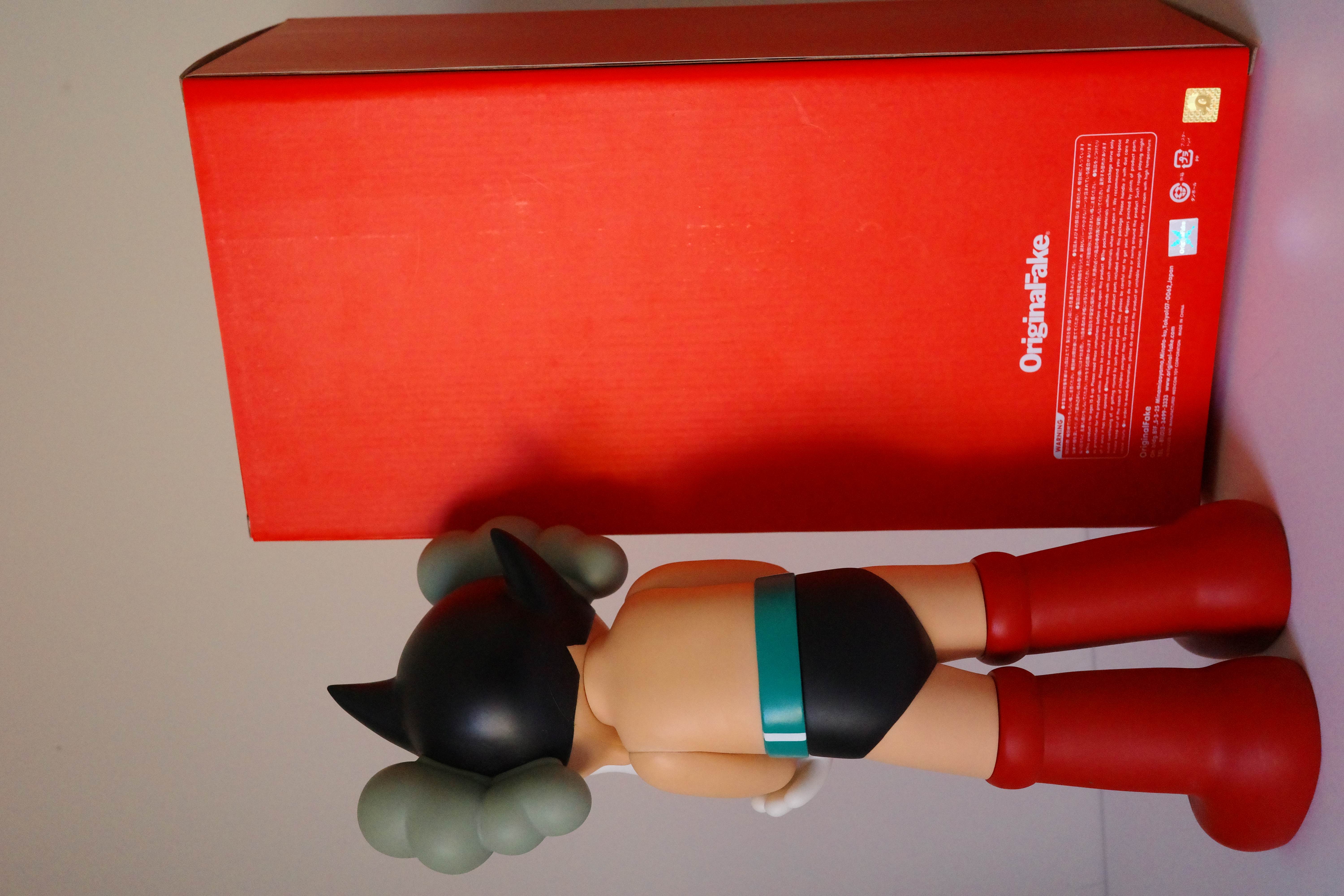 A figurine of a woman laying on the ground with her head in her hands.