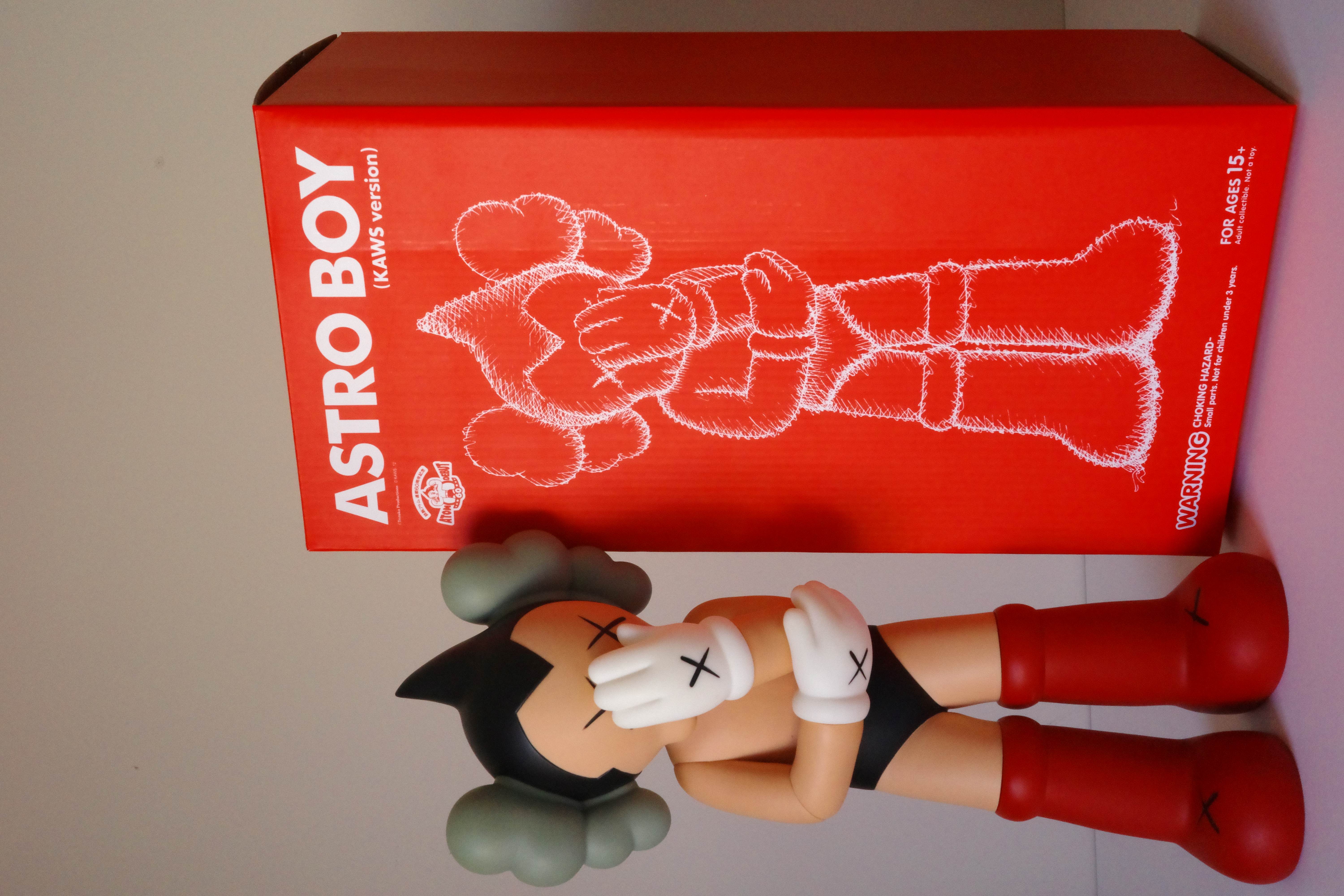 A figurine of a woman laying on the ground with her head in her hands.