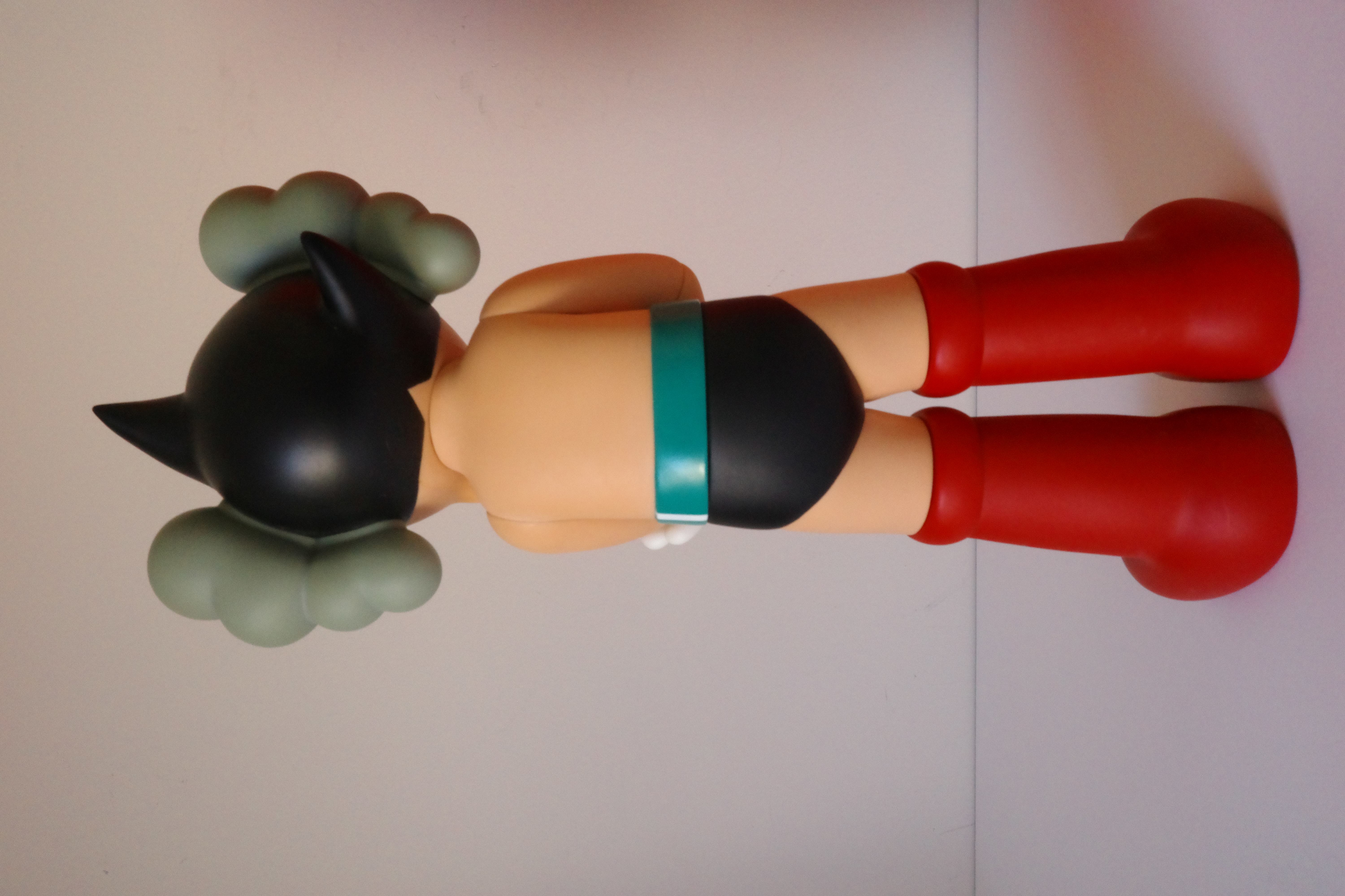 A figurine of a woman laying on the ground with her head in her hands.