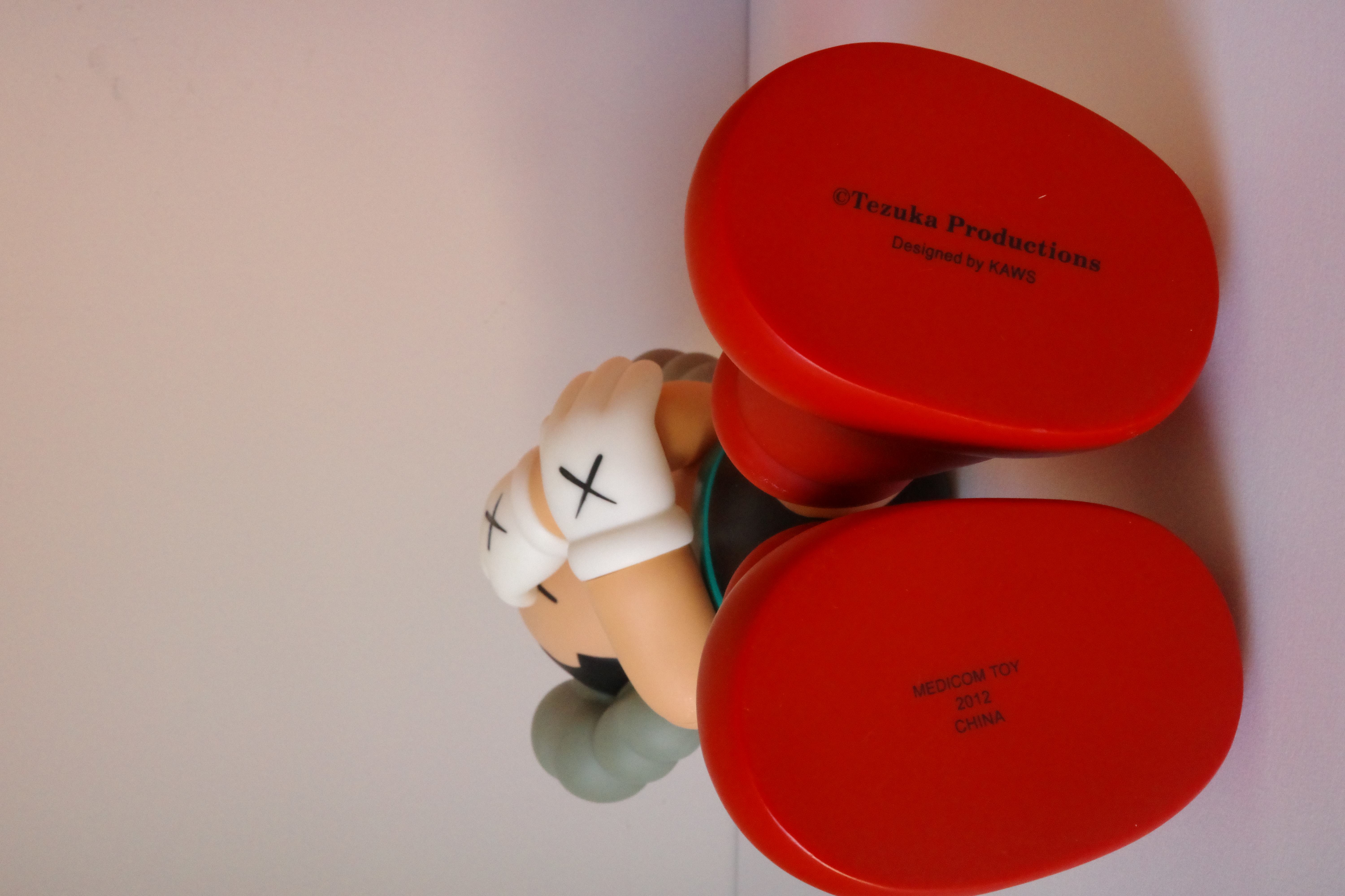 A figurine of a woman laying on the ground with her head in her hands.