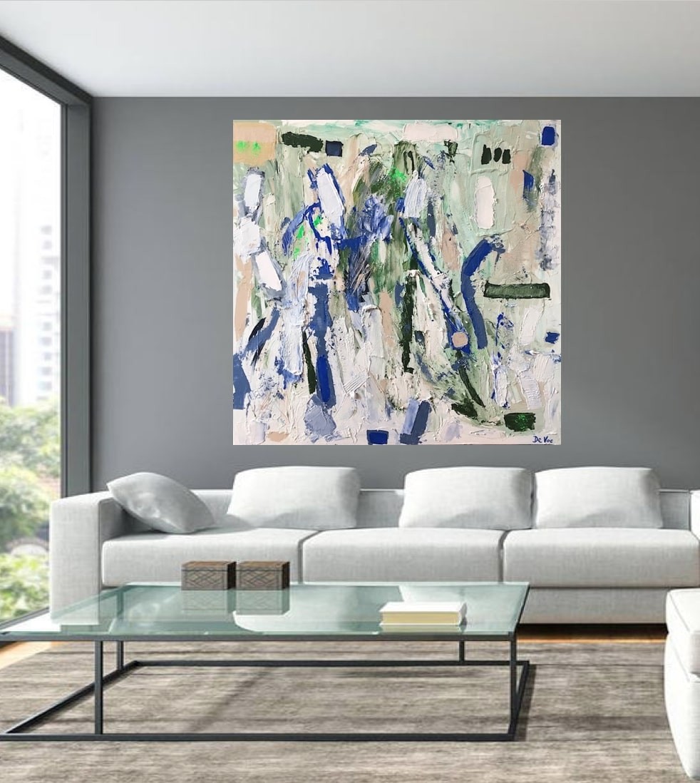 A living room with a white couch and a painting on the wall.