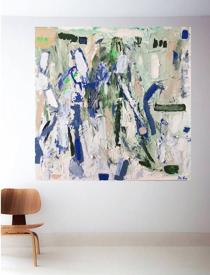 A living room with a white couch and a painting on the wall.