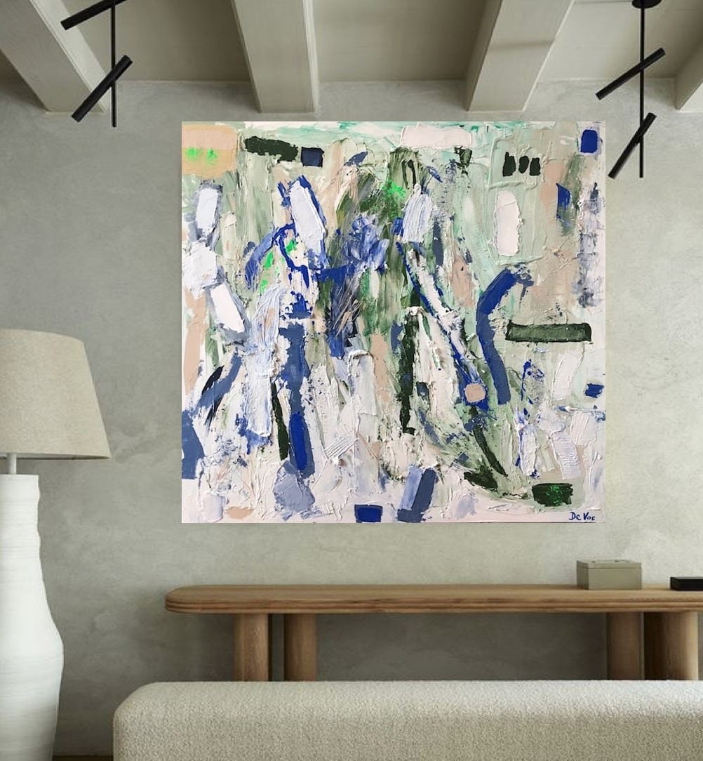 A living room with a white couch and a painting on the wall.