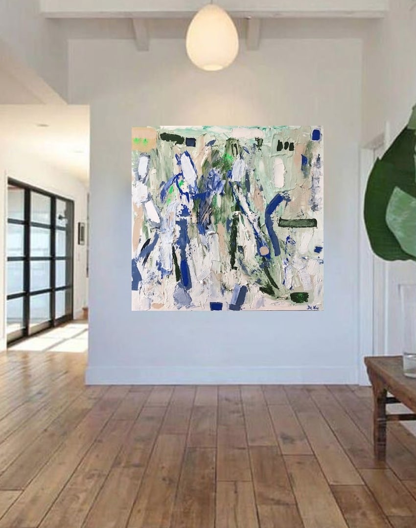 A living room with a white couch and a painting on the wall.