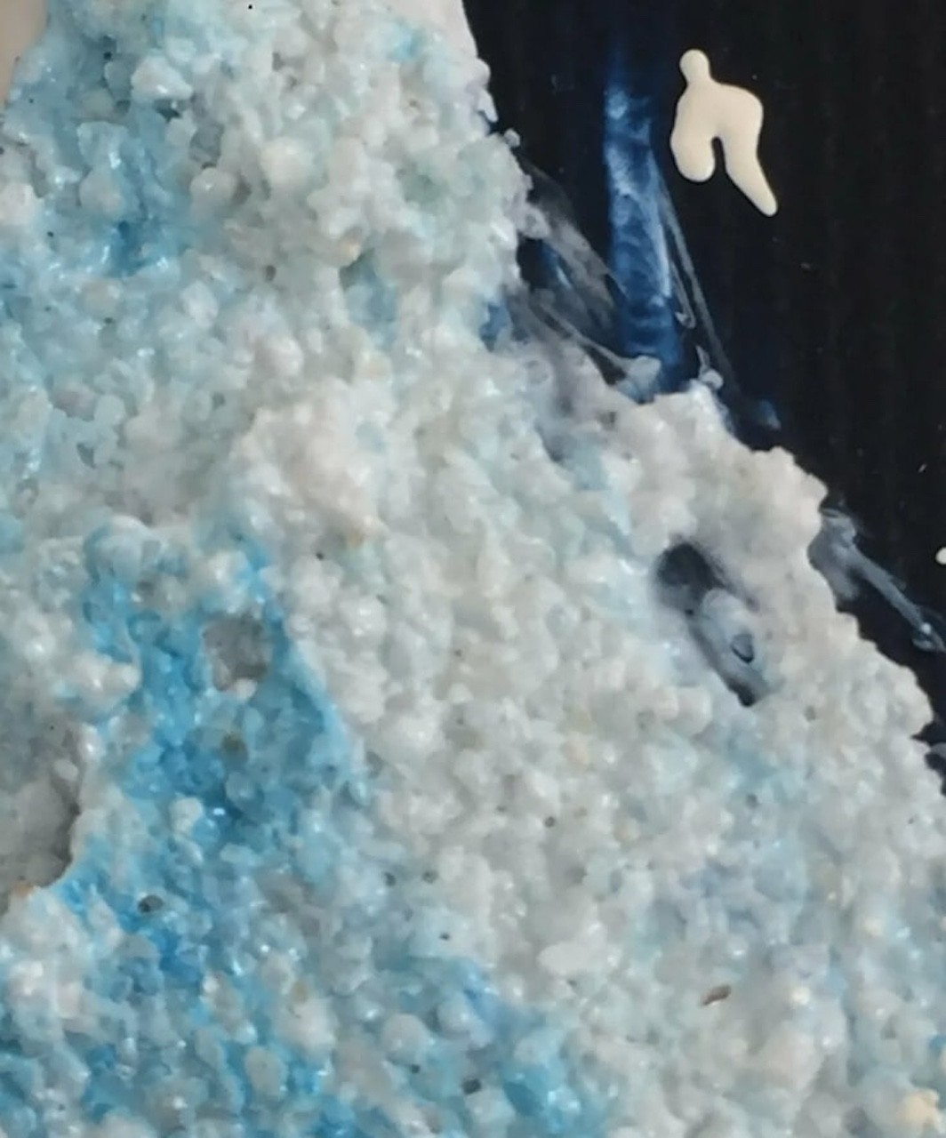 A close up of a blue and white bath bomb.