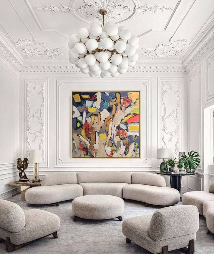 A painting in a gold frame on a white wall.