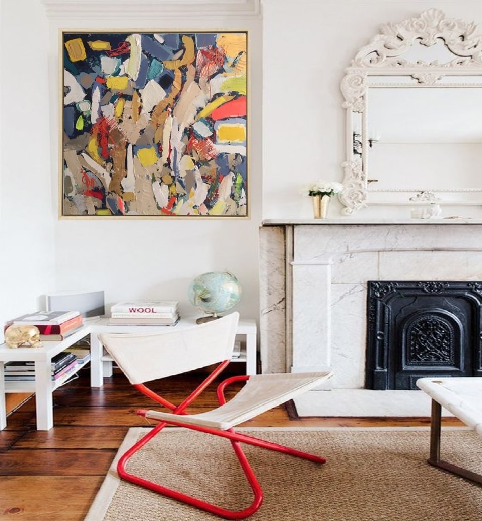 A painting in a gold frame on a white wall.