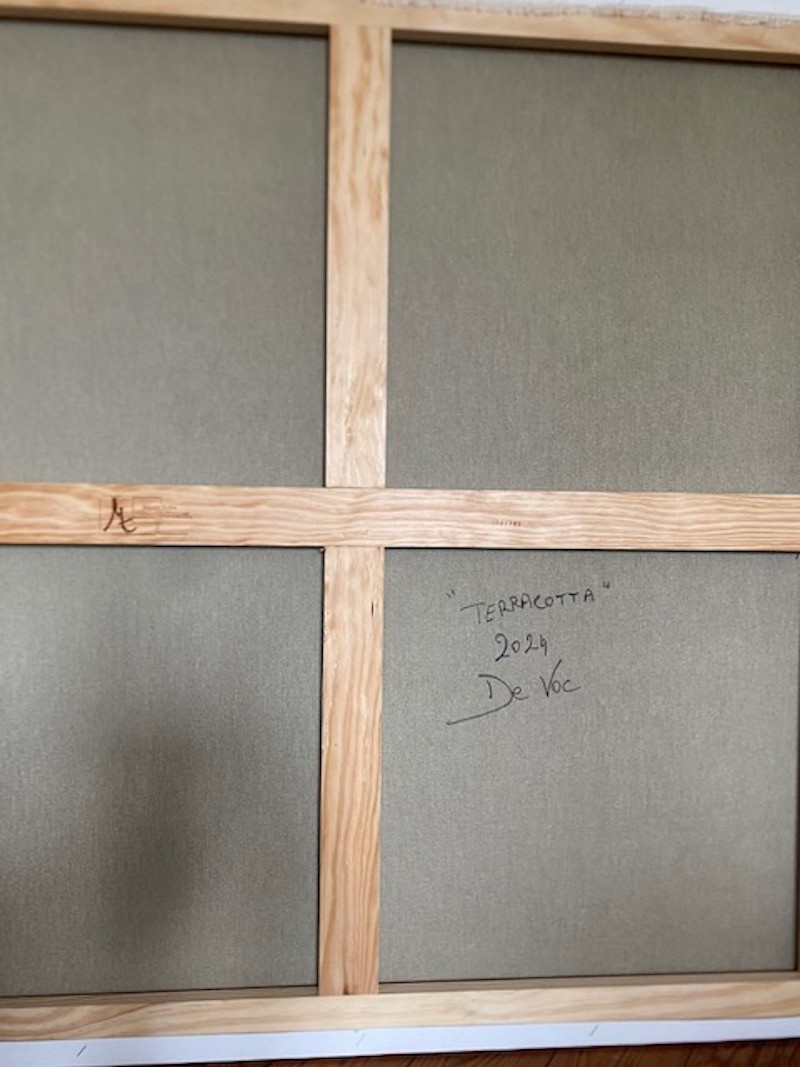 A painting with a wooden frame on a white wall.