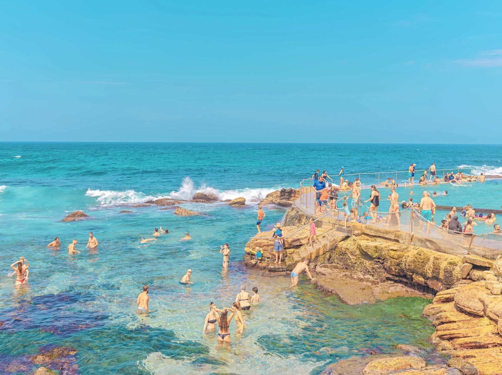 A group of people standing on top of a rocky beach.