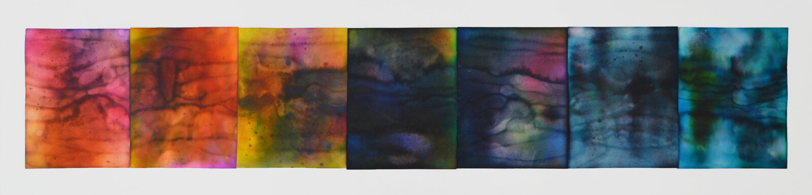 A horizontal abstract composition of seven rectangular panels displaying a spectrum of blended colors.