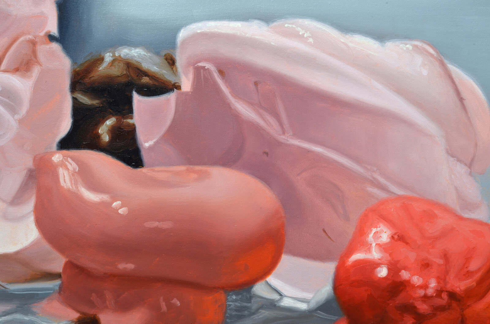 A surreal still life featuring fleshy pink forms and a dark, organic shape against a split background.
