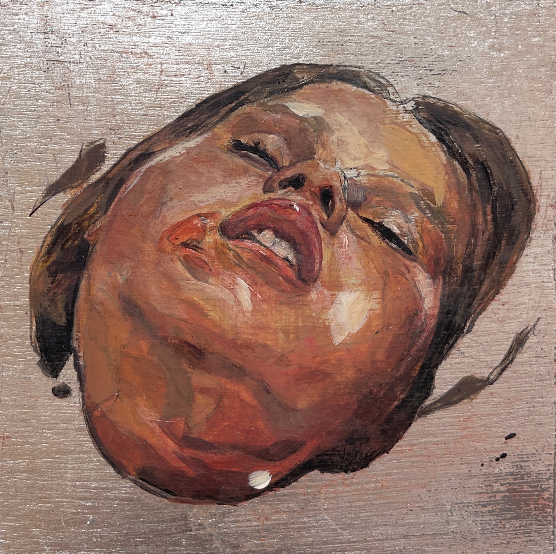 A painting of a woman's face on a wooden surface.
