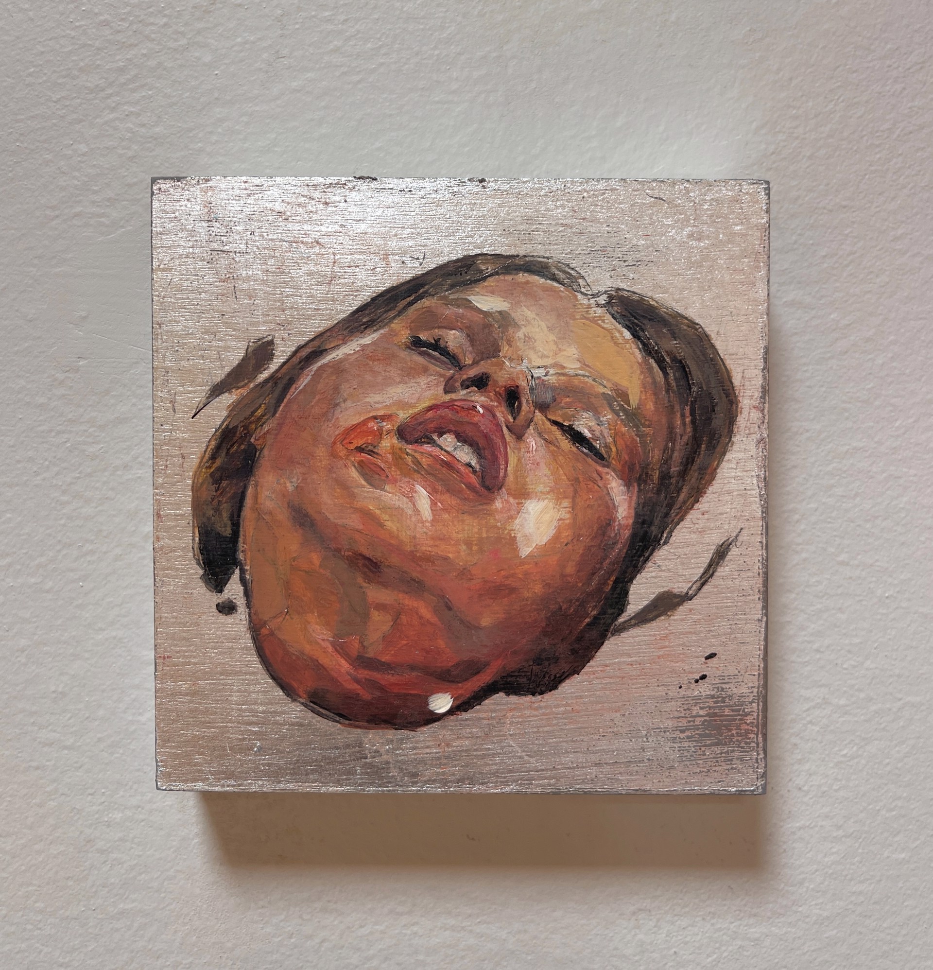 A painting of a woman's face on a wooden surface.