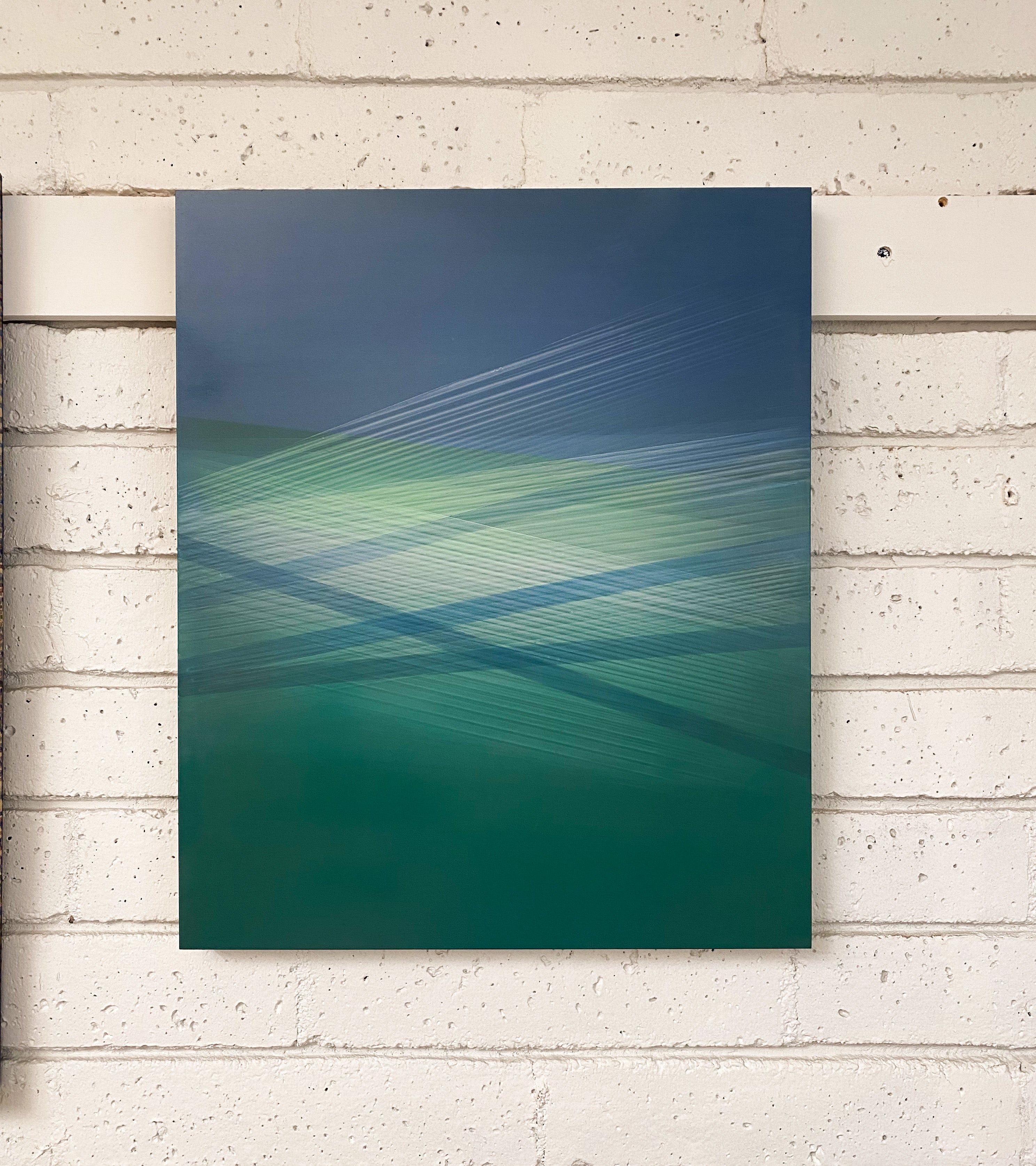 A blue and green abstract painting on a white background.