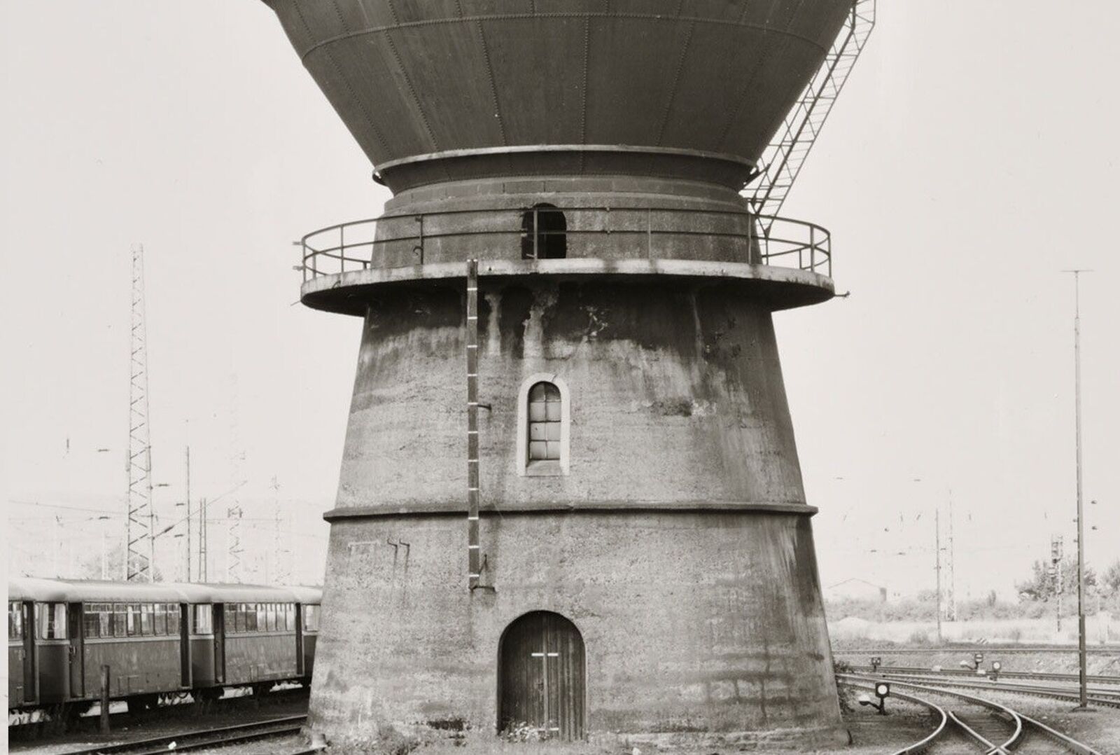 A black and white photo of a water tower on a wall.