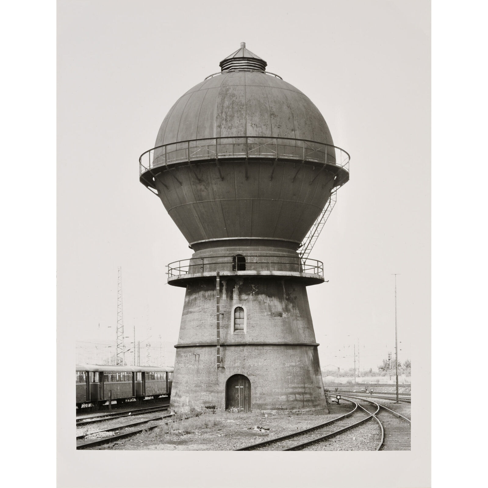 A black and white photo of a water tower on a wall.