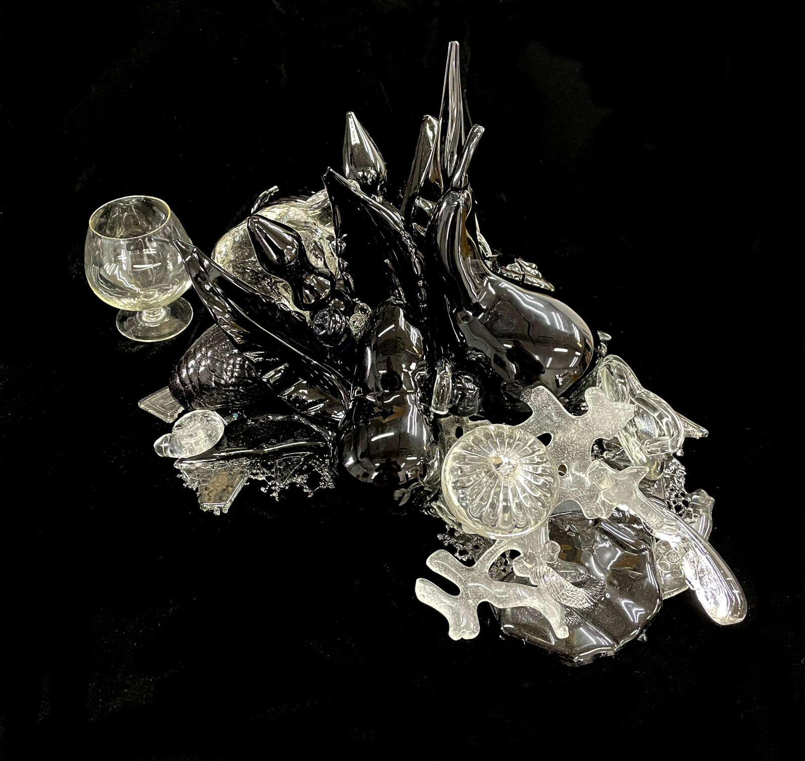 A chaotic assemblage of shattered glass and dark glossy shards against a void.