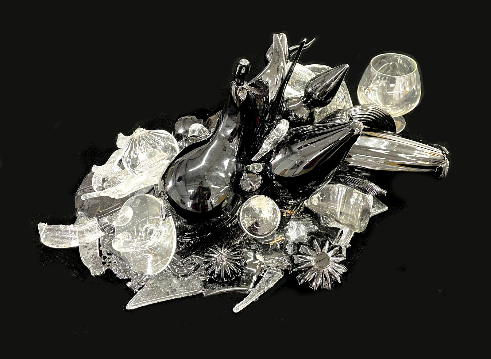 A chaotic assemblage of shattered glass and dark glossy shards against a void.