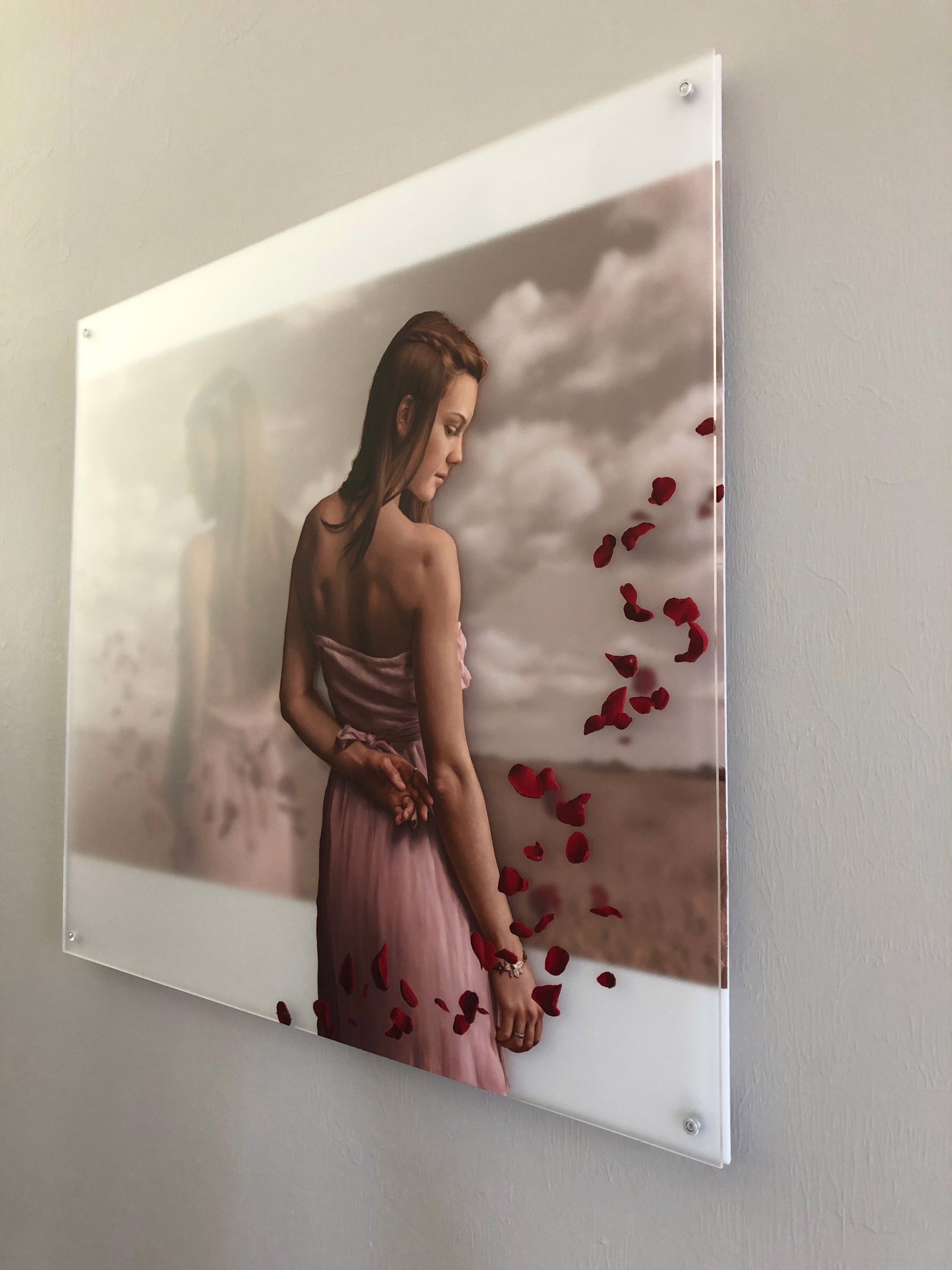 A woman in a pink dress standing in a field of rose petals.