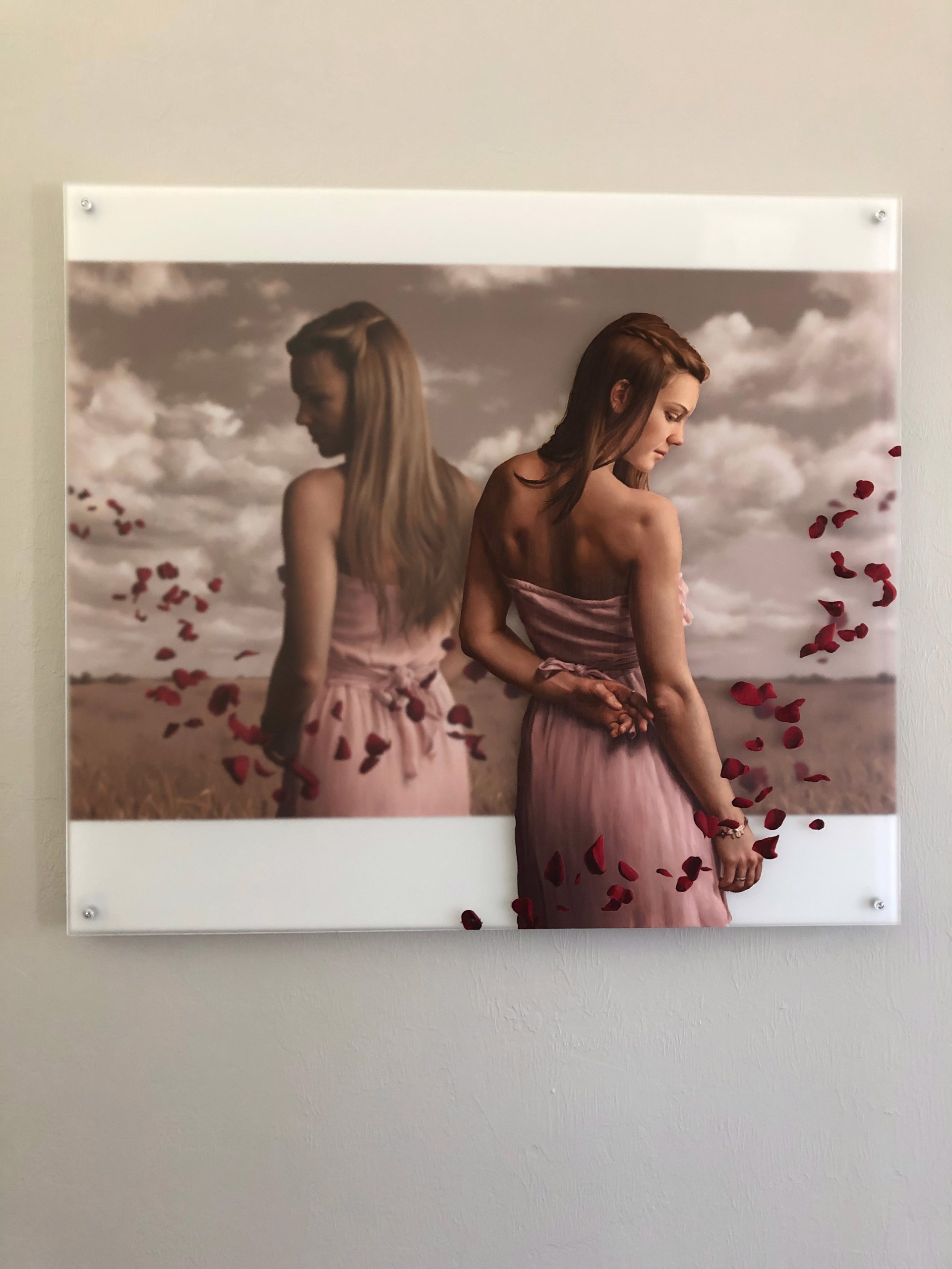A woman in a pink dress standing in a field of rose petals.