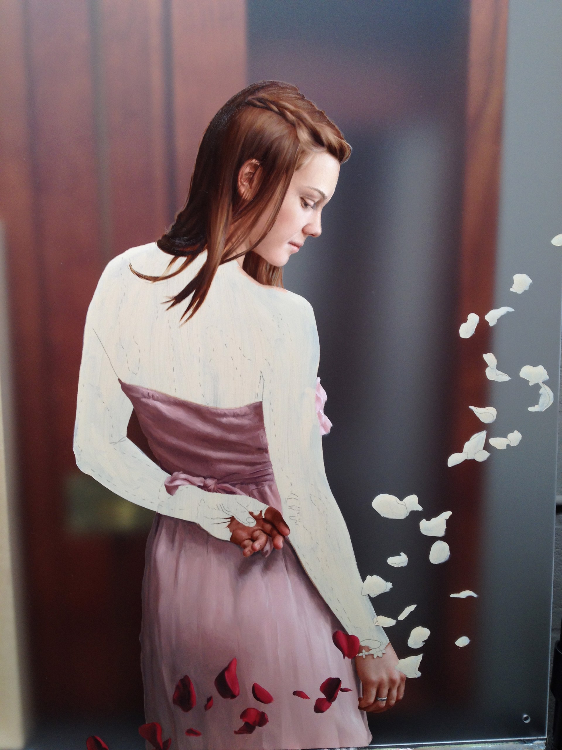 A woman in a pink dress standing in a field of rose petals.