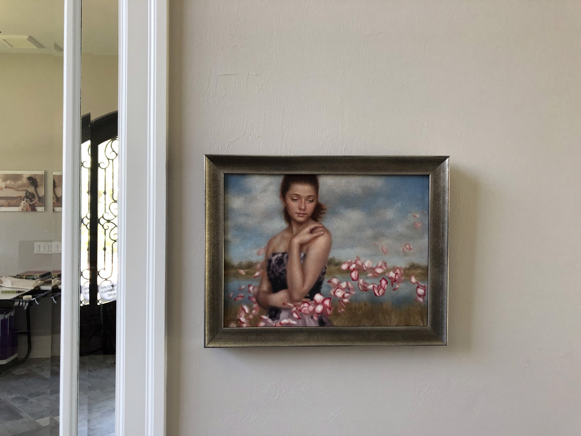 A painting of a woman in a field of rose petals.