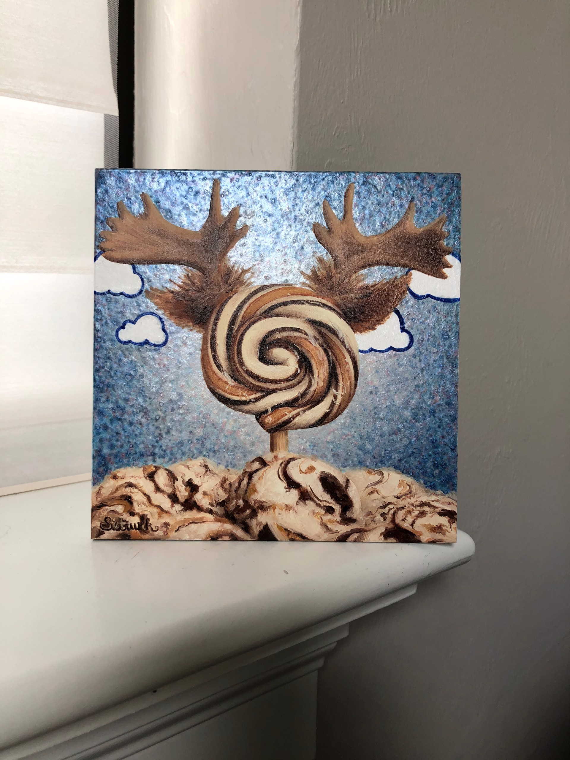 A painting of a lollipop with antlers on top of it.