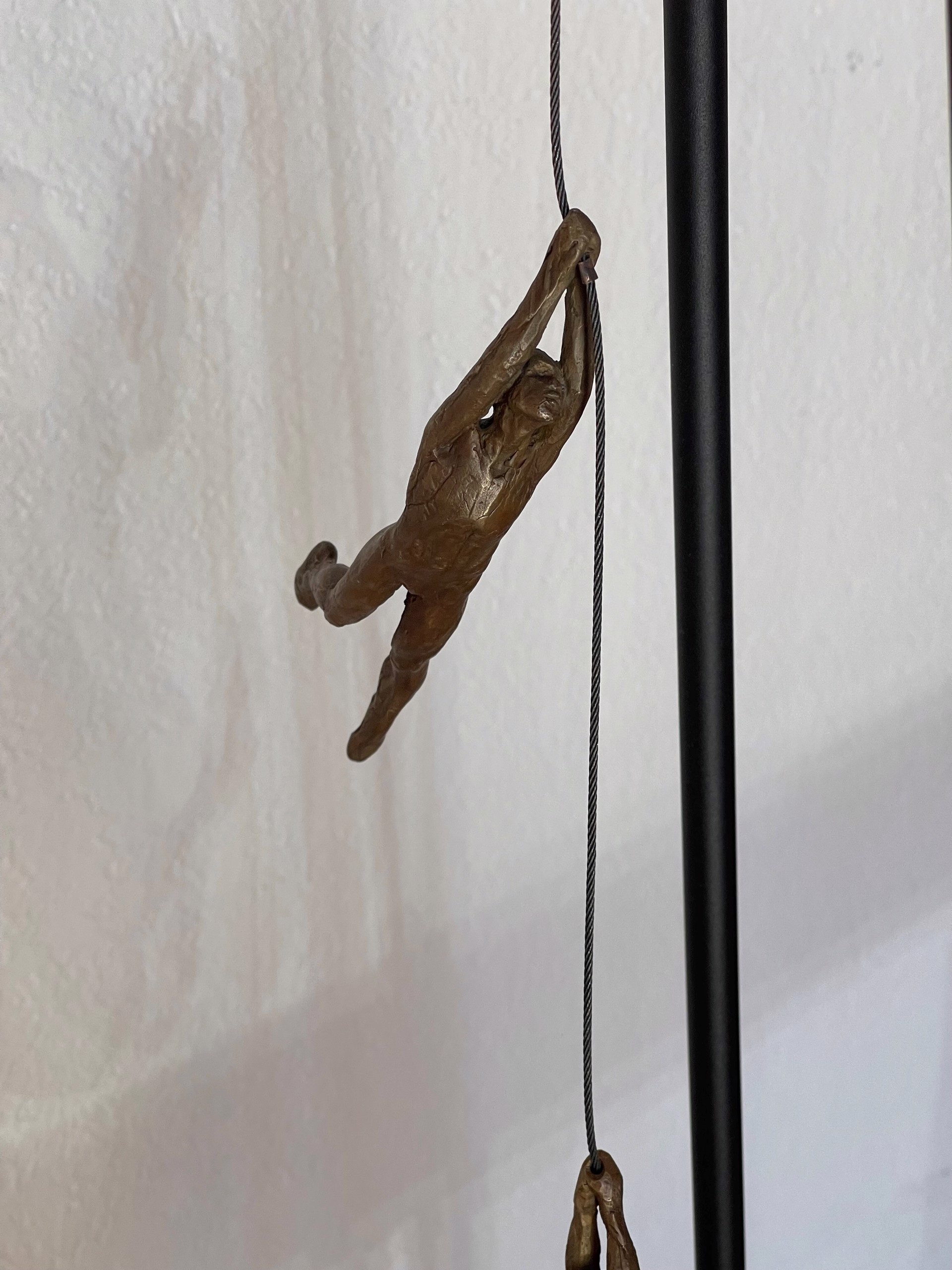 A bronze sculpture of a man sitting on top of a table.