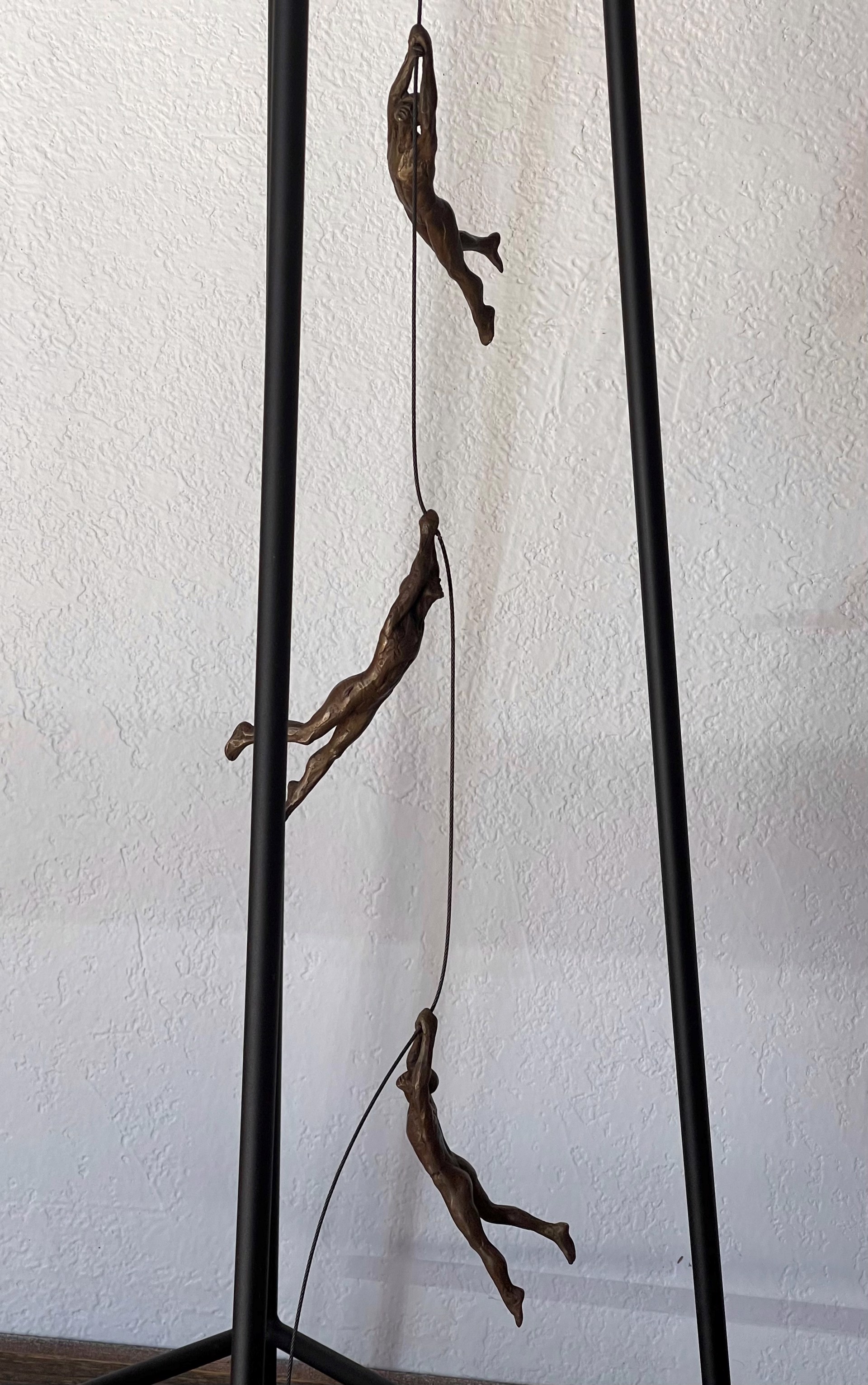 A bronze sculpture of a man sitting on top of a table.