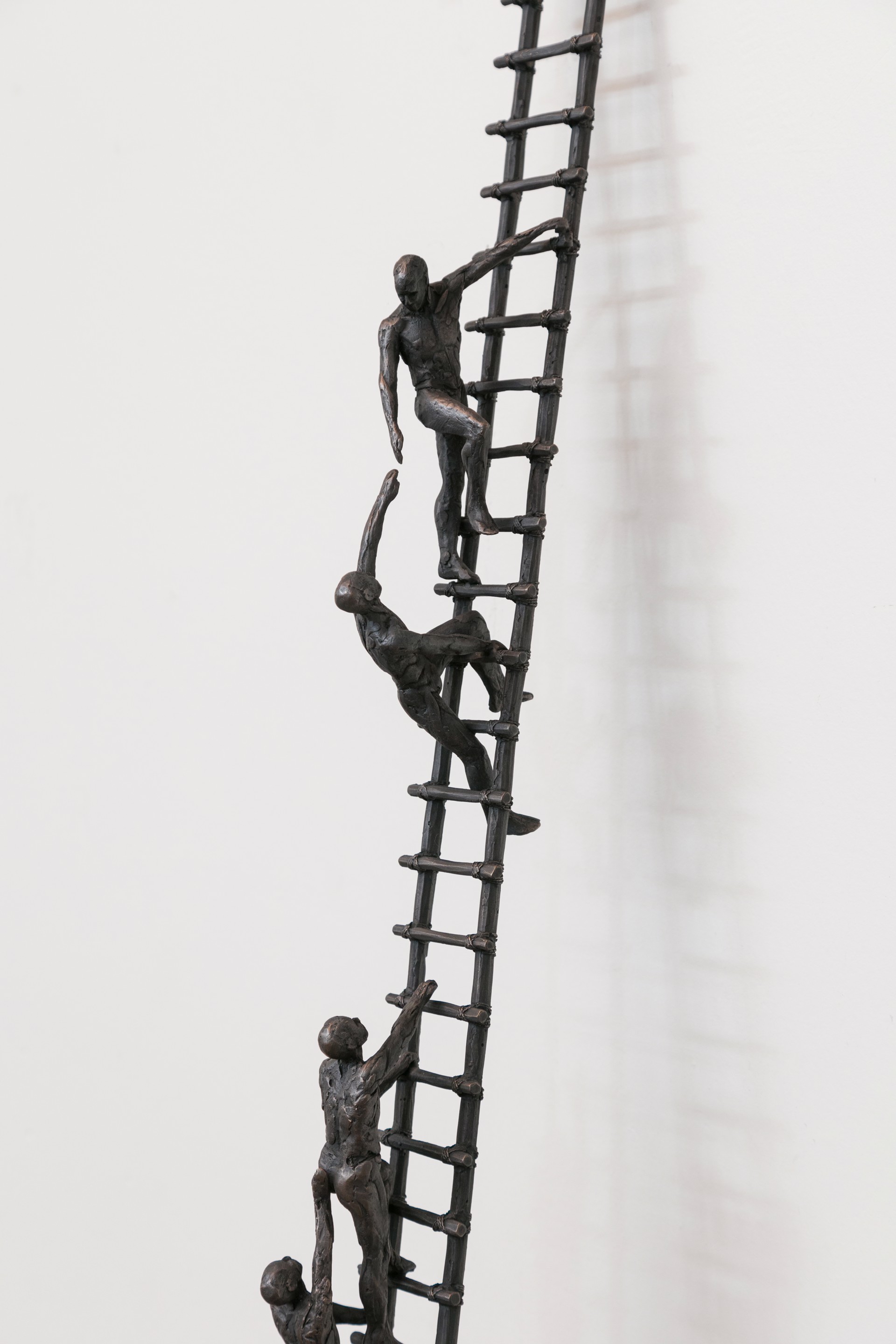 A tall metal ladder with people climbing up it.