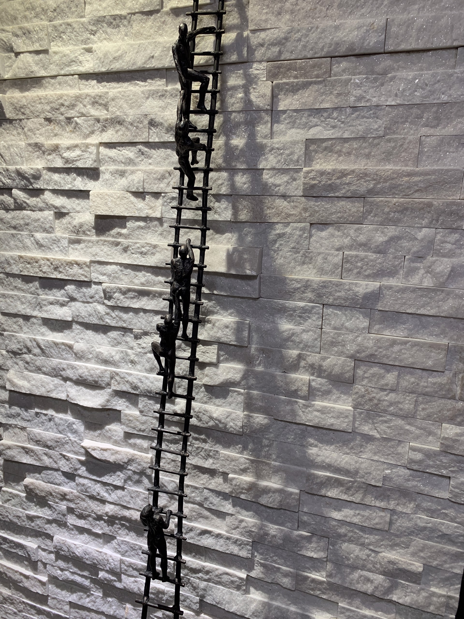 A tall metal ladder with people climbing up it.