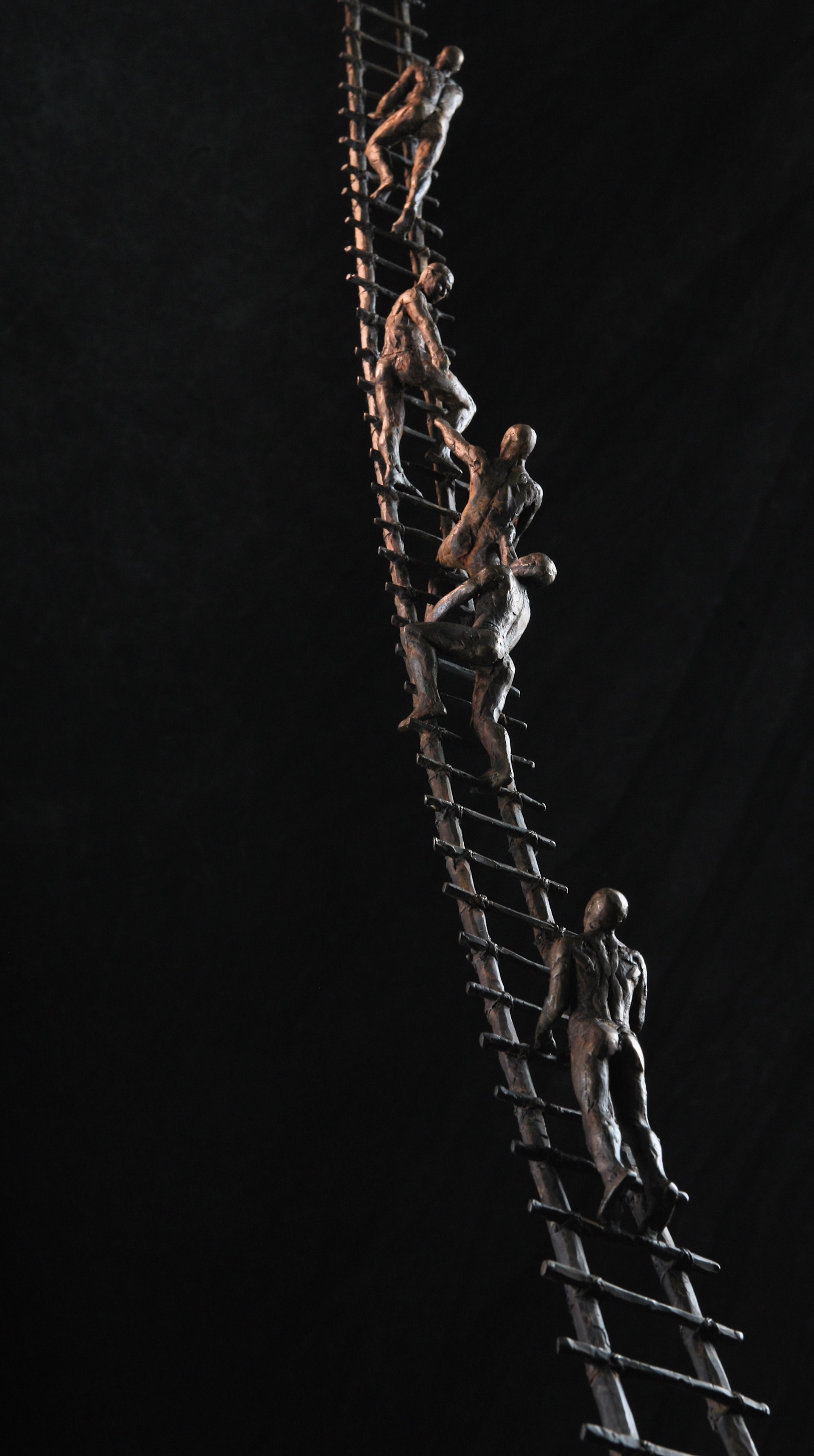 A tall metal ladder with people climbing up it.