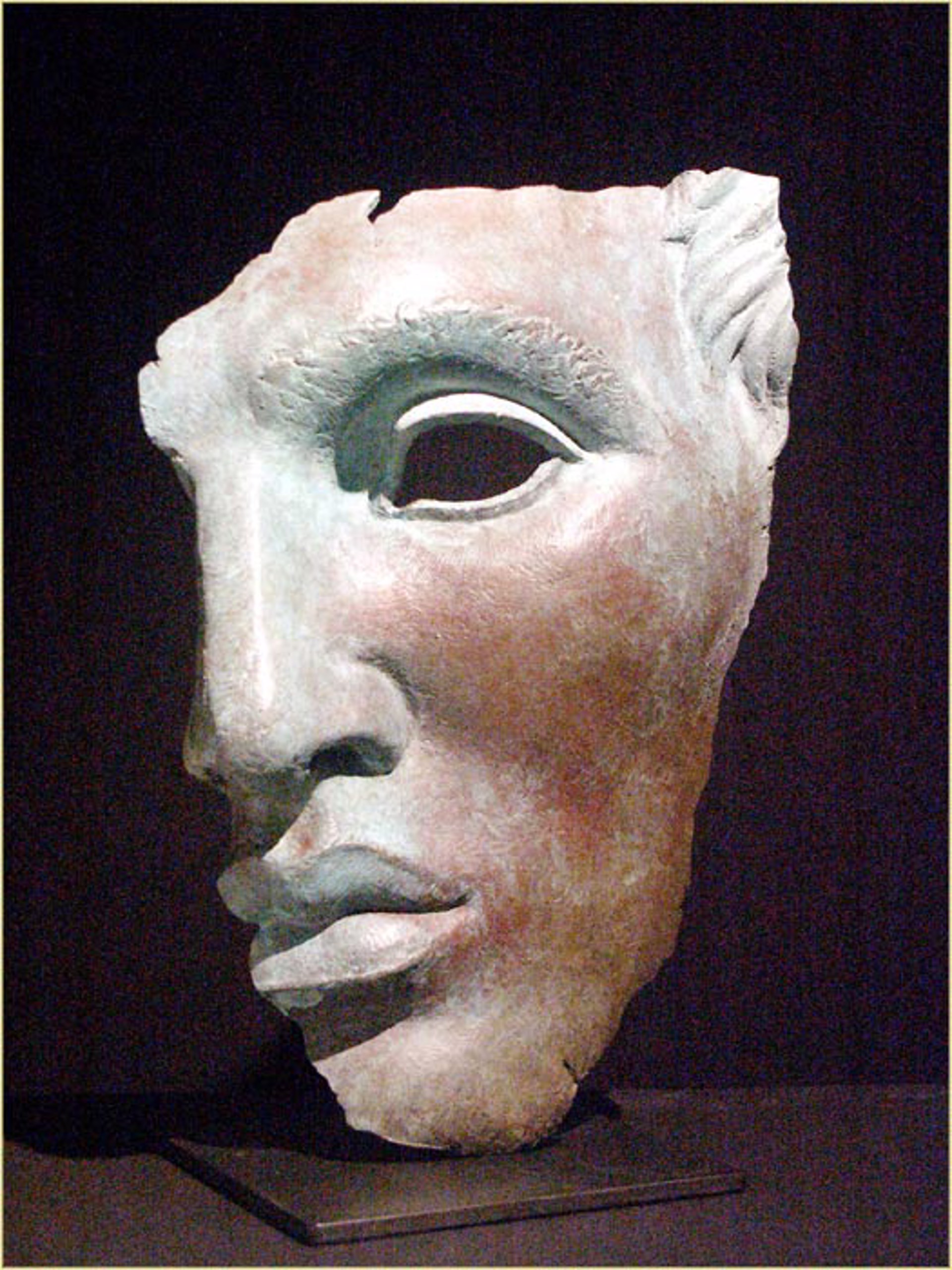 A clay mask on display in a museum. 