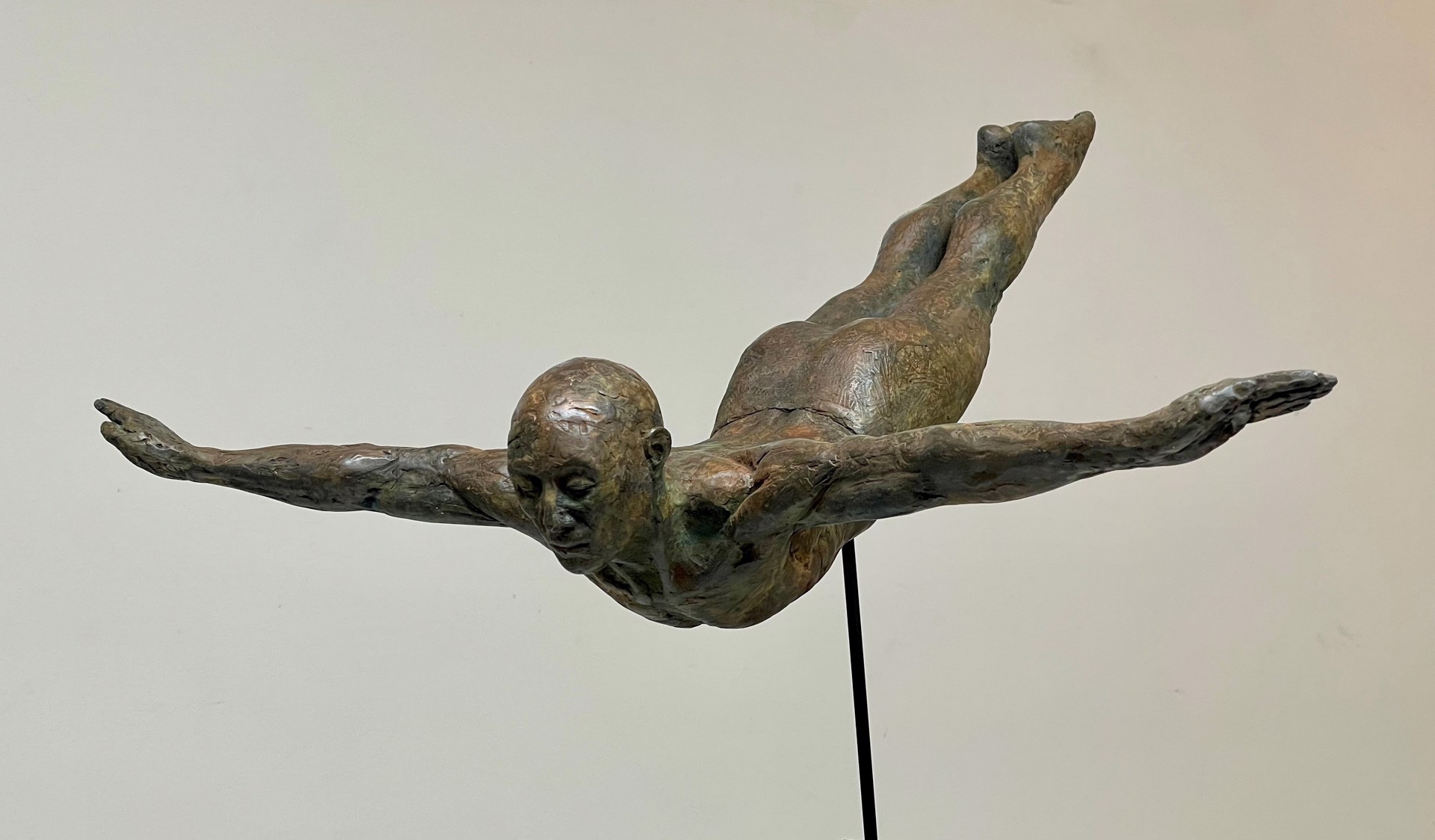 A bronze sculpture of a man diving into the water.