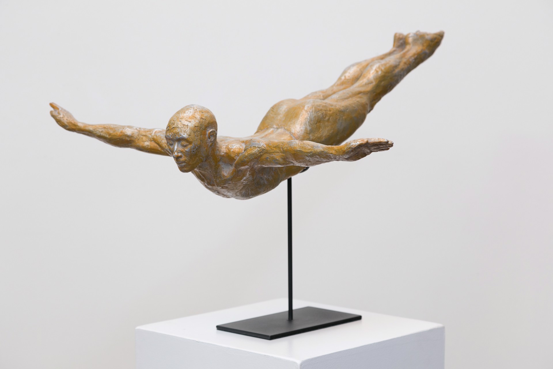 A bronze sculpture of a man diving into the water.