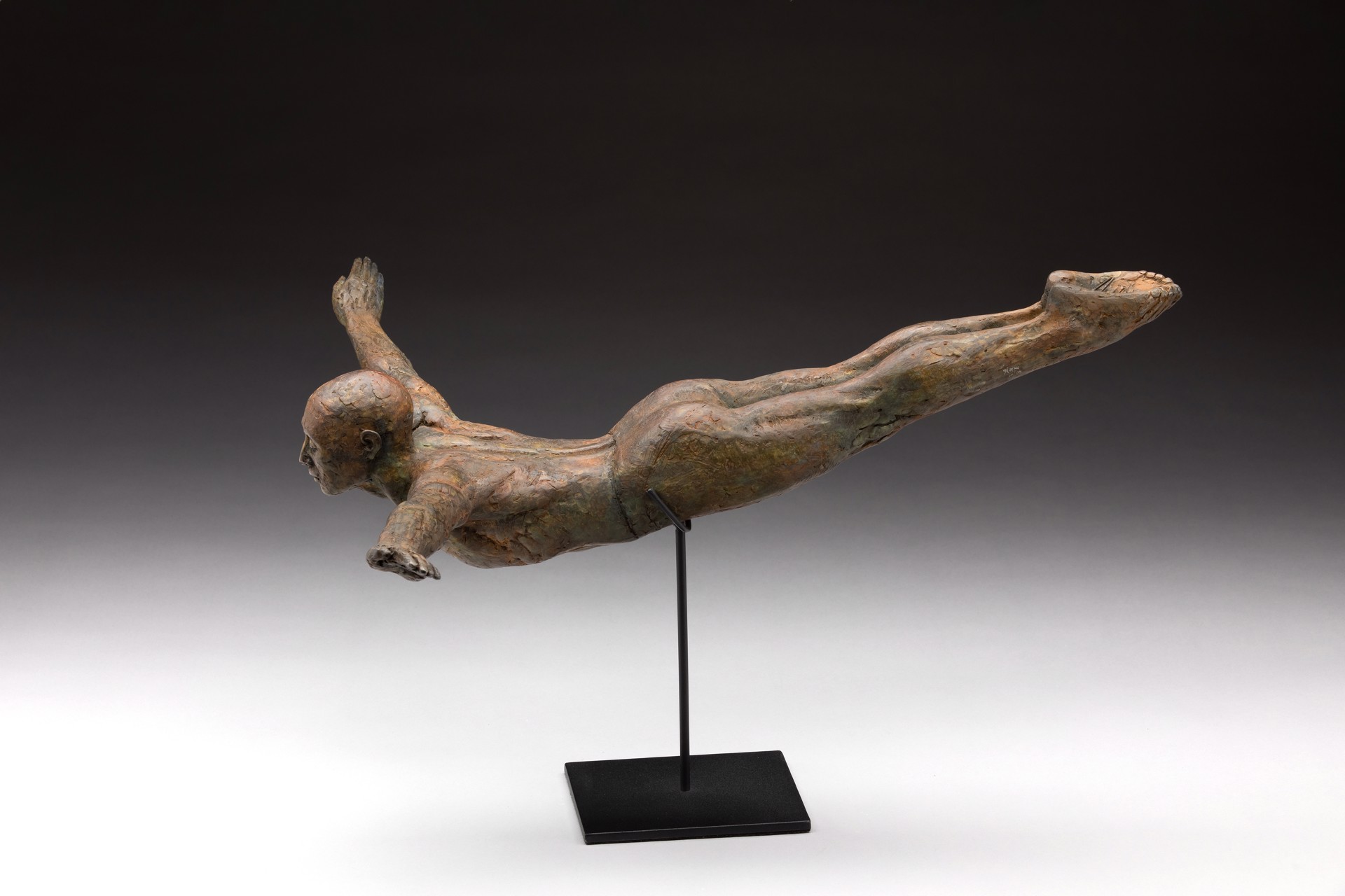 A bronze sculpture of a man diving into the water.
