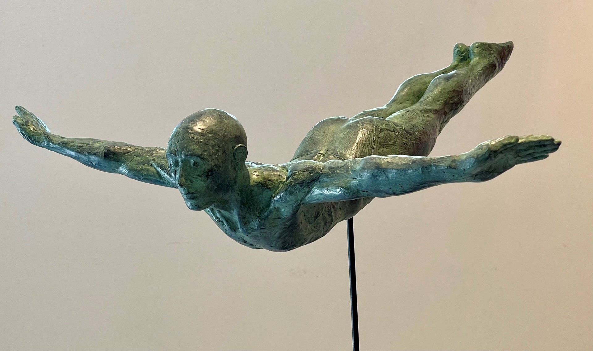 A bronze sculpture of a man diving into the water.
