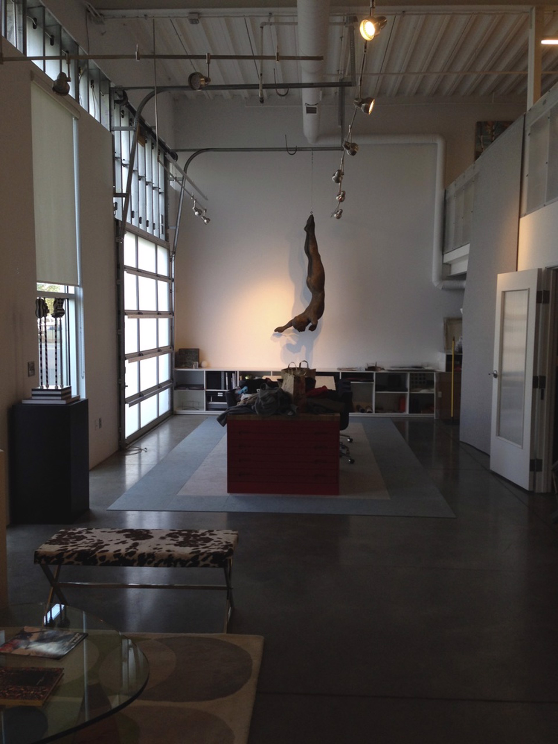 Two bronze figures appear to be floating or diving in mid-air against a stone wall.