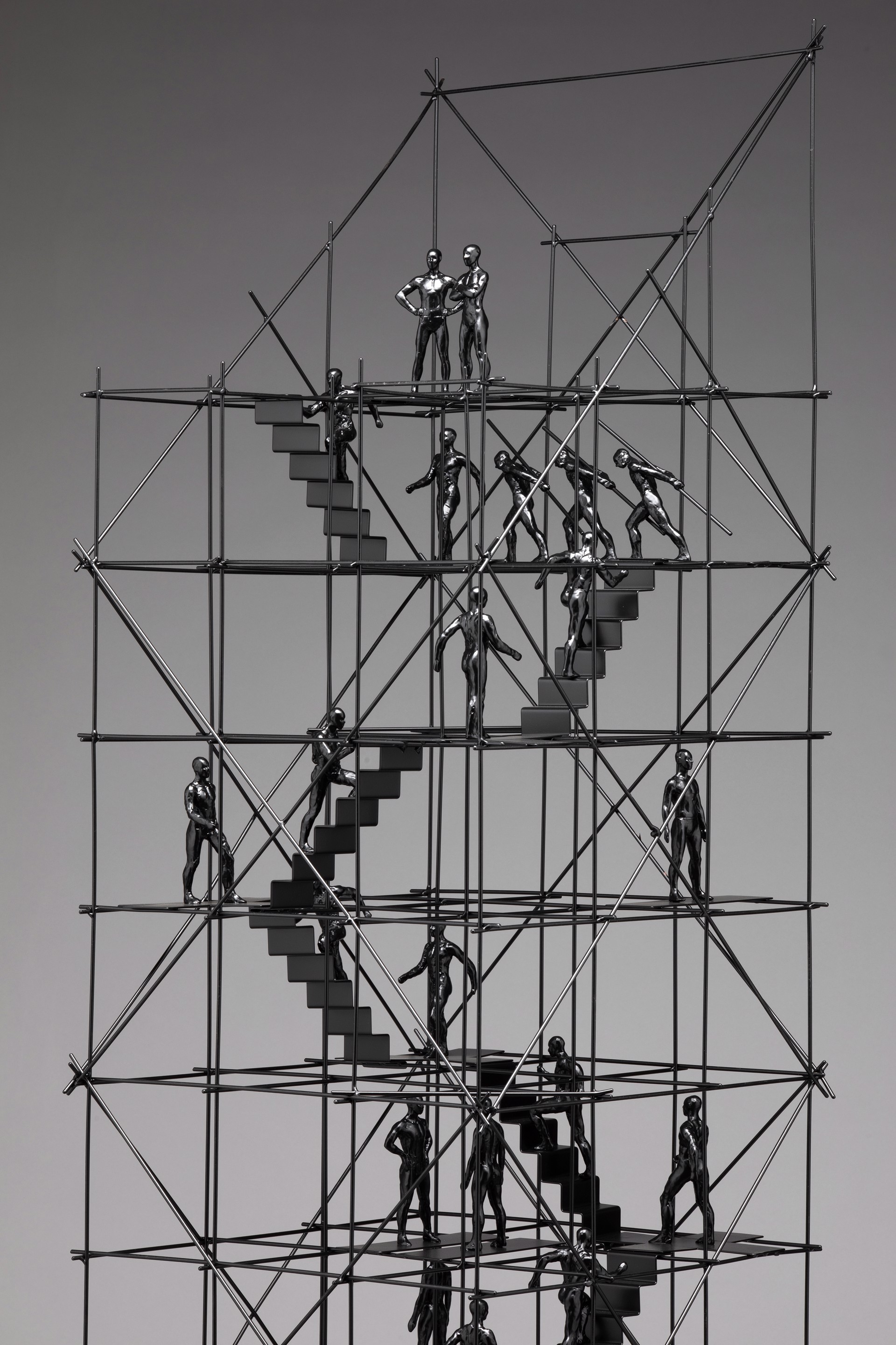 A sculpture of a group of people climbing up a set of stairs.