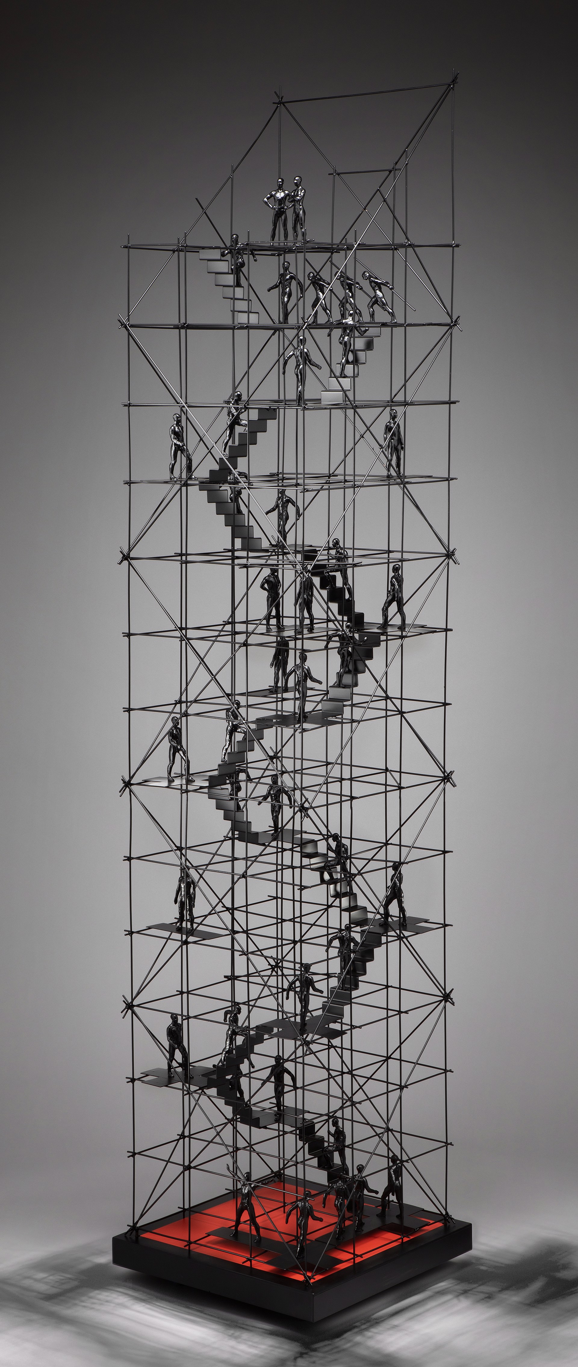 A sculpture of a group of people climbing up a set of stairs.
